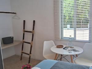 una stanza con un tavolo e un tavolo bianco e sedie di Hotel Posada Mykonos a Bacalar