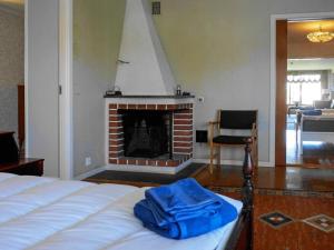 a bedroom with a bed and a fireplace at 7 person holiday home in SKÄRHAMN in Skärhamn