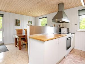 a kitchen with white cabinets and a stove top oven at 6 person holiday home in Ulfborg in Ulfborg