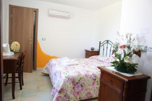 a bedroom with a bed and a desk and a table with a table at Agriturismo Il Pavone in Torre Lapillo