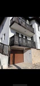 a large white building with a garage with a brown door at La Vista 1 in Veliko Tŭrnovo +4 photos
