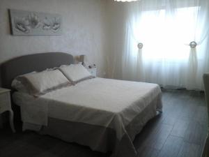ラ・スペツィアにあるCarpe Diemのベッドルーム(白いベッド1台、窓付)