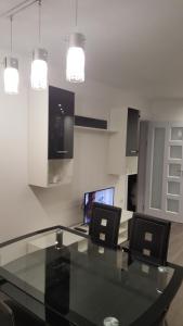 two laptops sitting on a glass table in a room at Luxe Apartment Pana Green Residence Panagyurishte in Panagyurishte