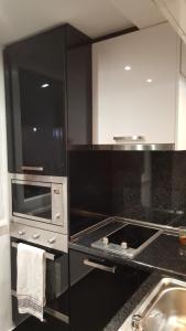 a kitchen with a stove and a microwave at Luxe Apartment Pana Green Residence Panagyurishte in Panagyurishte