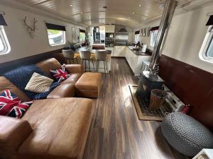 a living room with couches and a stove in an rv at Selene Unique Luxury Houseboat Experience in Chertsey