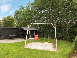 a swing set in a yard with a playground at Luxury Retreat with Spa - By Traum Ferienwohnungen in Hemmet
