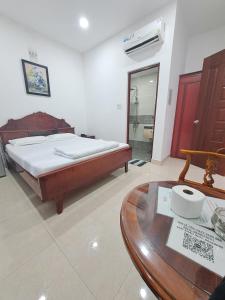a bedroom with a bed and a wooden table at Khách sạn sen hồng 1 in Cao Lãnh +6 photos