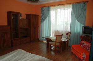 a bedroom with a table and a room with a bed at Raj Muszyna Apartamenty z widokiem na panoramę górską in Muszyna