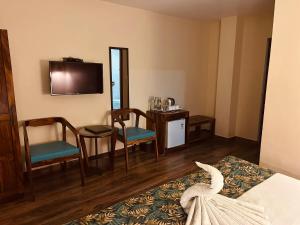 a hotel room with a bed and a table and chairs at SeaScape Port Blair in Port Blair
