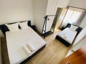 a bedroom with a bed with white sheets and a mirror at Canaan Hôtel Antsirabe in Antsirabe