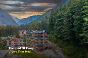 a view of a building in a valley with mountains at goSTOPS Kasol PLUS, Manikaran Road - Private Rooms & Dorms in Kasol