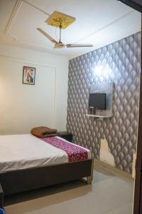 a bedroom with a bed and a tv on a wall at Sher E Punjab Home Stay in Agra