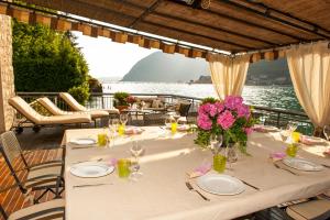 einen Tisch mit Tellern und Blumen auf einer Terrasse in der Unterkunft Villa Sofia in Sulzano