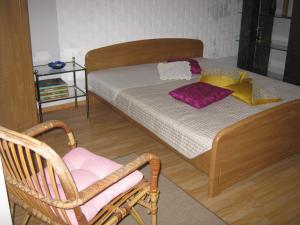 a bedroom with a bed and a chair and a chair at Guesthouse Linna in Vodice