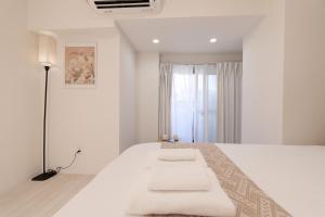 a bedroom with a white bed with a lamp and a window at Home Story in Tokyo Ueno&Uguisudani-小島ビル&東京屋語 in Tokyo +92 photos