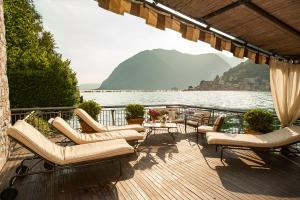 eine Terrasse mit Stühlen und Tischen und Blick auf das Wasser in der Unterkunft Villa Sofia in Sulzano