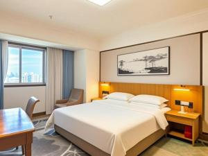 厦门Xiamen Jingmin Central Hotel的一间酒店房间，配有一张大床和一张书桌 更多257张照片