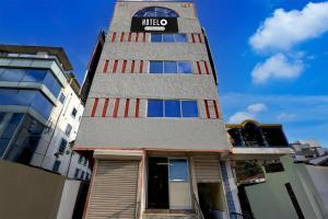 a tall building with a sign on top of it at Hotel O Egmore Metro Station Chennai Formerly Harini Lodge in Chennai