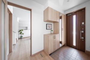 a hallway with a wooden door and a mirror at The Vertex in Asahikawa