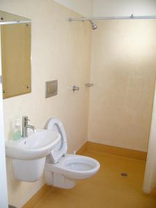 a bathroom with a white toilet and a sink at Verandahs Parkside Lodge in Auckland