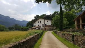 a dirt road in front of a white house at Mas Rubió in Joanetes