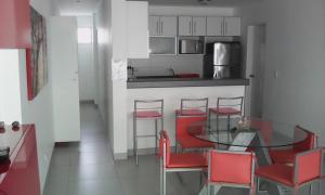 a kitchen with a glass table and red chairs at Paracas Beach Vacation Rentals in Paracas