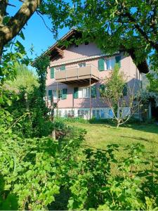 a large pink house with a yard with trees at Swiss Alpine view apartment in Interlaken +12 photos