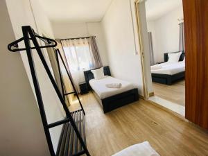 a small room with two beds and a mirror at Canaan Hôtel Antsirabe in Antsirabe