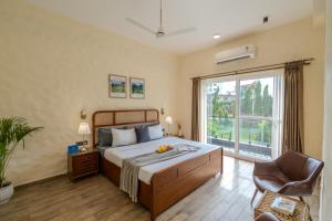 a bedroom with a bed and a large window at SaffronStays Tarangini by Ganges in Rishīkesh