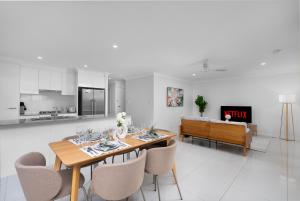 a kitchen and dining room with a table and chairs at Stylish 3-Bedroom Duplex in Pİmpama, Close to M1 in Pimpama