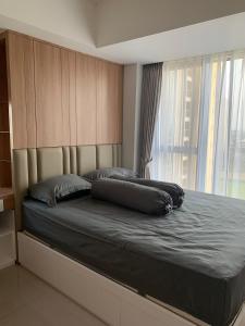 ein Bett in einem Schlafzimmer mit einem großen Fenster in der Unterkunft The Branz BSD city luxurious and cozy apartment in Samporo