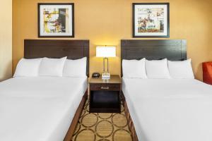 a hotel room with two beds and a table with a lamp at Econo Lodge in Taber +47 photos