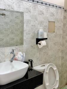 a bathroom with a sink and a toilet and a mirror at Homestay Hoa Hồng in Liên Trì (4)