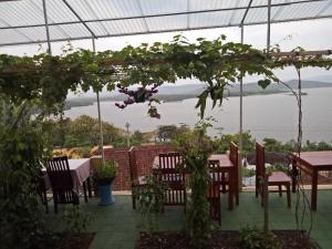 a patio with tables and chairs and a view of the water at OYO Life 91323 Omah Victoria Homestay & Culinary in Tempuran