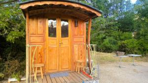 a wooden out house with stools in front of it at Hôtel Restaurant L Orée du Vercors in Montmaur-en-Diois
