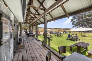 an outdoor deck with people sitting on tables and chairs at French Island General Store 