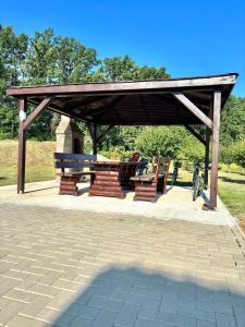 a wooden pavilion with benches and a bike under it at Pensiune Agroturistică RAY 