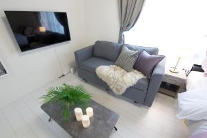 una sala de estar con un sofá y una mesa en 渋谷区代々木302, en Tokio