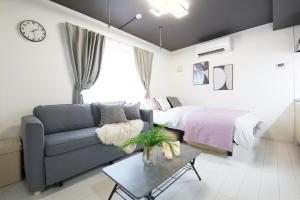 una sala de estar con un sofá y una cama en 渋谷区代々木302, en Tokio