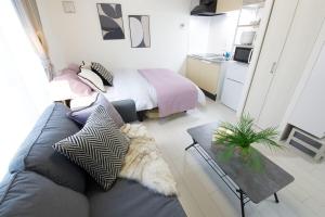 una sala de estar con un sofá y una cama en 渋谷区代々木302, en Tokio 19 fotos más