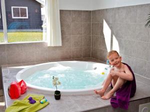 a young boy sitting in a bath tub at Luxury Pool Retreat in Kegnaes - By Traum Ferienwohnungen in Høruphav +8 photos