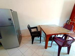 a kitchen with a table and chairs and a refrigerator at Sea Side Bay House in Weligama