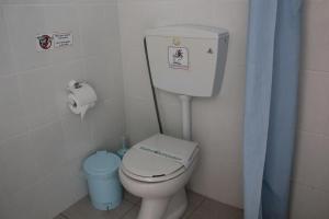 a bathroom with a toilet and a blue shower curtain at Maria Rooms in Agia Ermioni