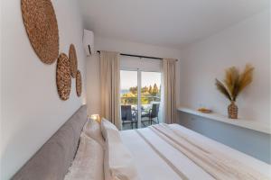 a white bedroom with a bed and a balcony at Gioiello Villa in Pefki Rhodes