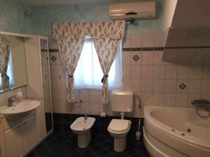 a bathroom with a toilet and a tub and a sink at Apartments Oliva in Poreč