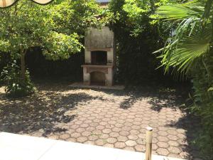 a stone patio with a bench in a garden at Apartments Oliva in Poreč