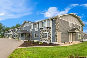 a large house with grey siding at Super 8 by Wyndham Alexandria MN in Alexandria