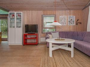 a living room with a purple couch and a table at 6 person holiday home in Glesborg-By Traum in Fjellerup +22 photos
