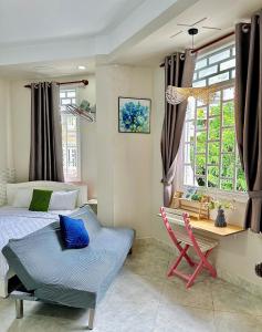 a bedroom with a bed and a chair and a window at Homestay Hoa Hồng in Liên Trì (4)