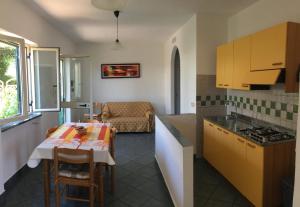 a kitchen and living room with a table and a couch at Villarosamaratea in Maratea